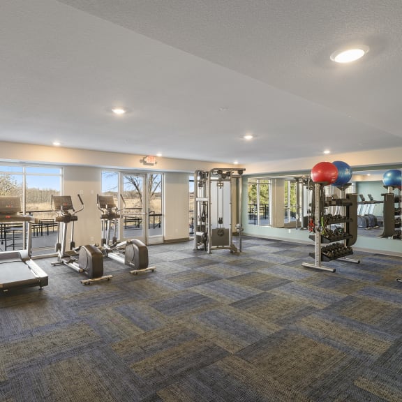 fitness center with exercise equipment and windows