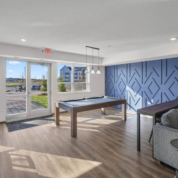 a clubroom with a pool table and a blue accent wall