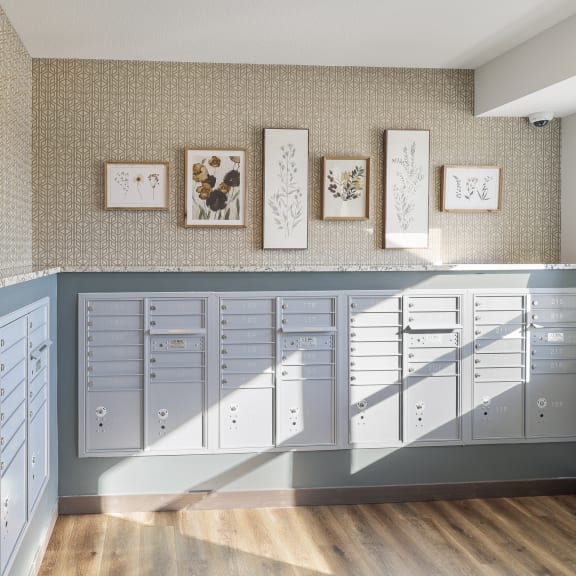 a mailroom with many cabinets and a wall with framed pictures