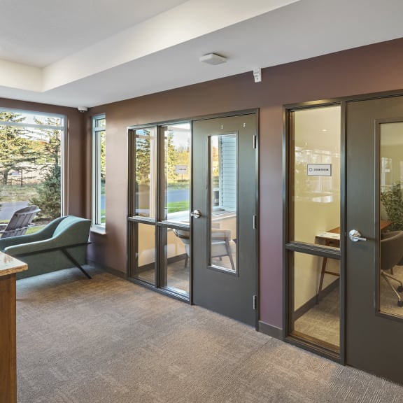 a conference room with glass doors and a table and chairs