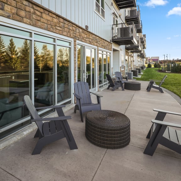 a patio with chairs and tables outside of a building