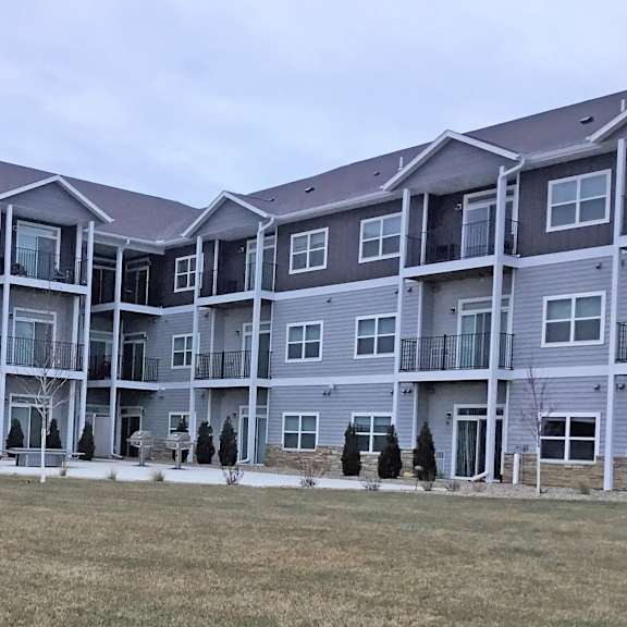an apartment building with a grass field in front of it