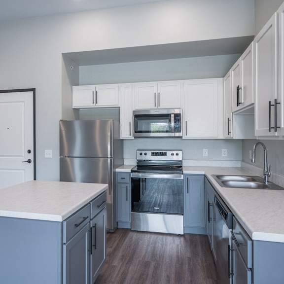 a kitchen with white cabinets and stainless steel appliances