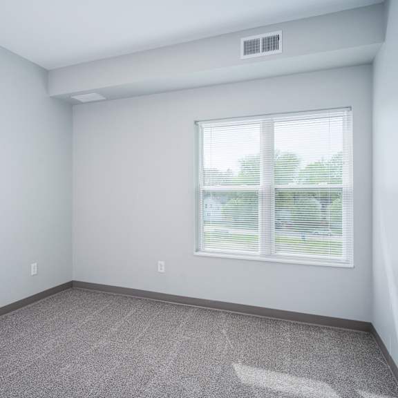 an empty room with white walls and a window