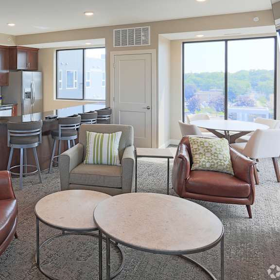 a living room with a brown leather chair and a white table.