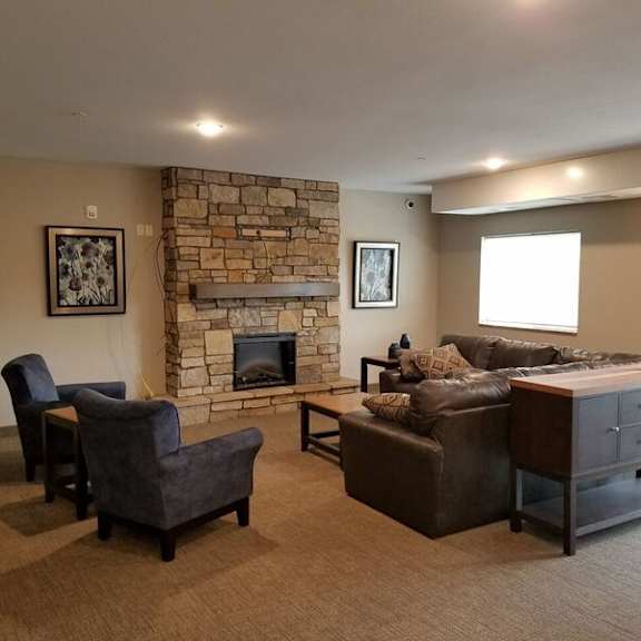 a living room with a stone fireplace and a couch.