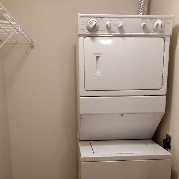 a white dryer and washer in a small room.