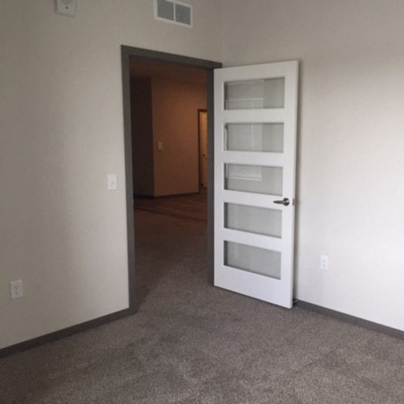 an empty room with an open white door