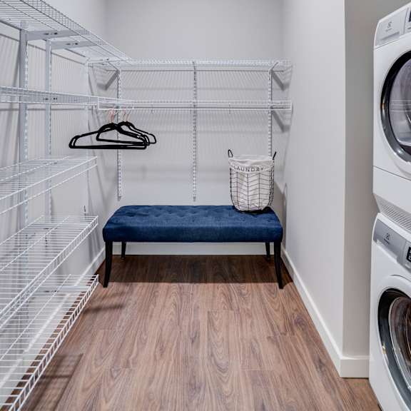 a laundry room with a bench and a washing machine.