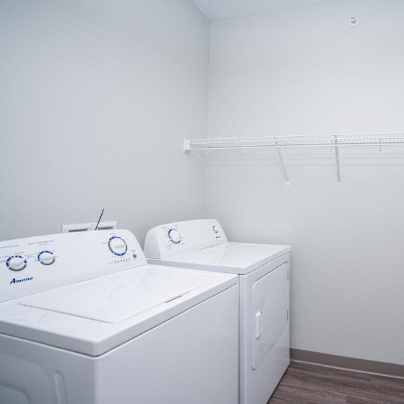 an empty laundry room with two washes and a dryer