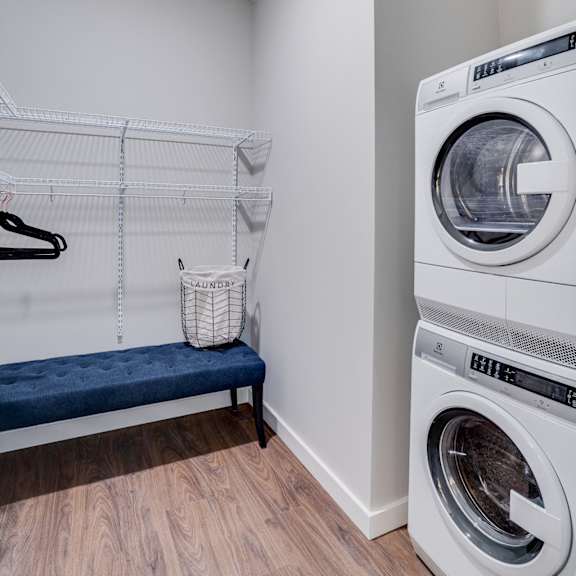 a laundry room with a washer and dryer stacked on top of each other.