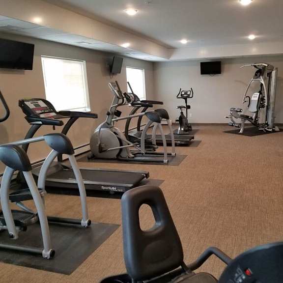 a gym with treadmills, elliptical machines, and other exercise equipment.