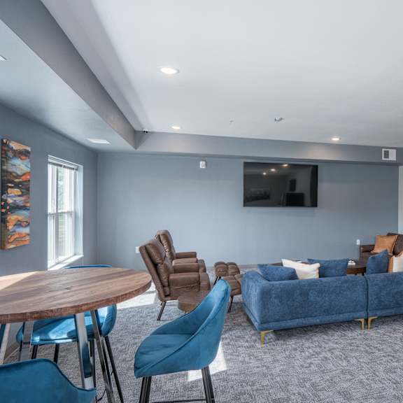 a living room with a blue couch and chairs and a table
