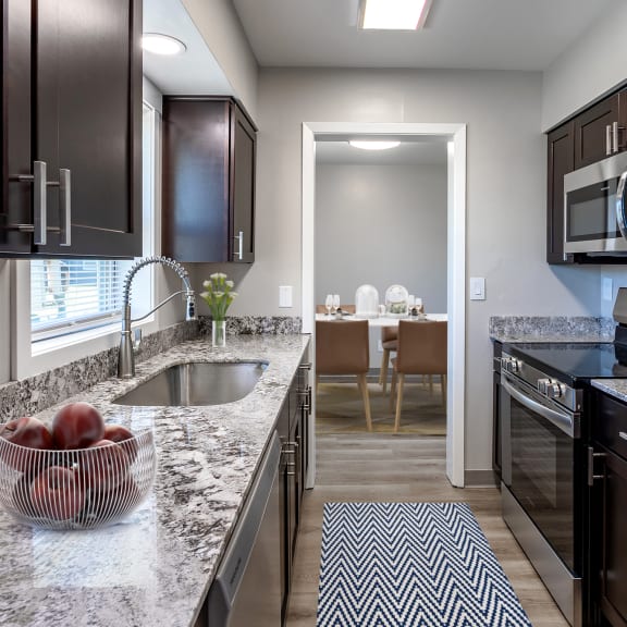 a kitchen with granite counter tops and stainless steel appliances