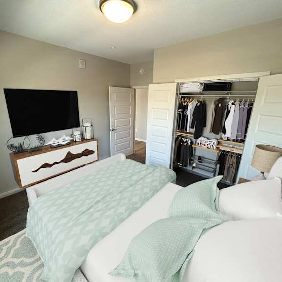 a bedroom with a bed, a dresser, and a wardrobe.