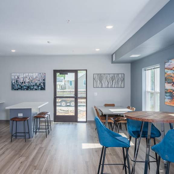 a dining room and kitchen with a table and chairs and a refrigerator and a door