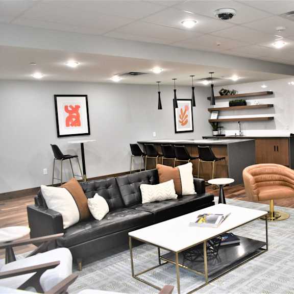 a modern living room with a black couch and a coffee table.