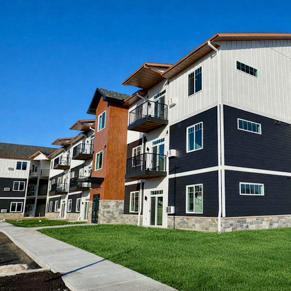a modern apartment building with a mix of white, black, and brown exterior colors.