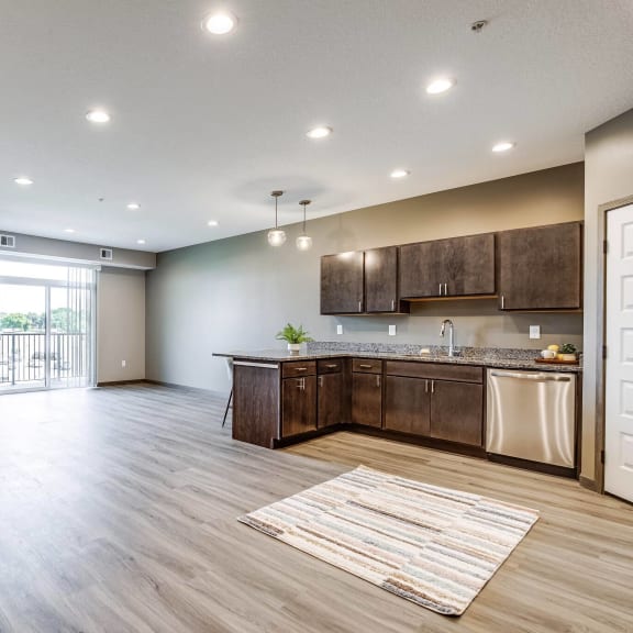 an open kitchen and living room with a door to a balcony