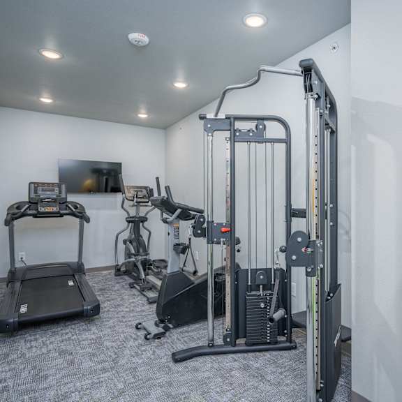 a gym with exercise equipment and a yellow ball on the floor