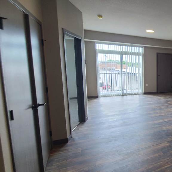 a kitchen and living room with a sliding glass door to a balcony