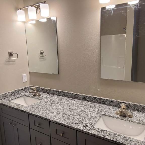 a bathroom with two sinks and a mirror