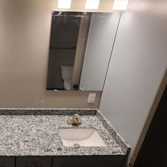 a bathroom with two sinks and two mirrors
