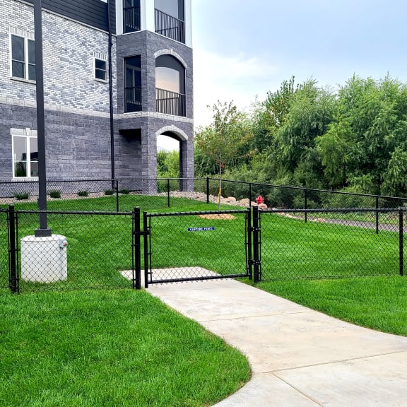 a house with a yard enclosed by a chain link fence