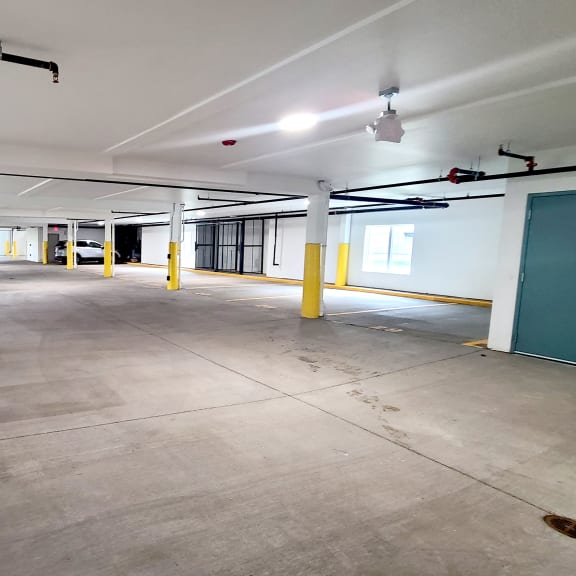 a parking garage with yellow pillars and a green door
