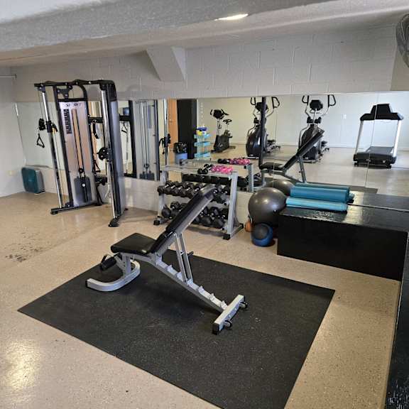 a gym with a variety of equipment including a leg press machine.