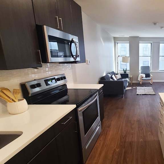 a kitchen with black cabinets and a white countertop.