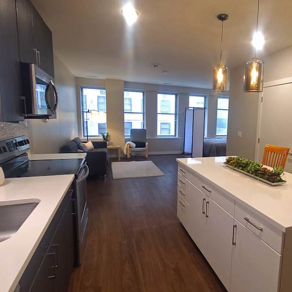 a kitchen with white countertops and wooden cabinets.