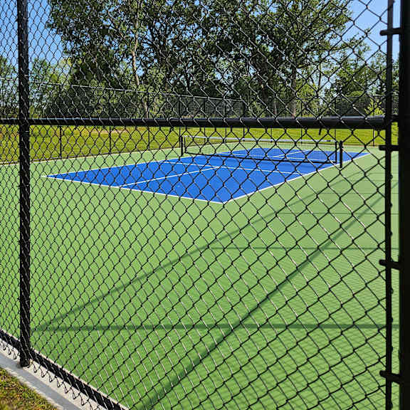 a blue and yellow umbrella is attached to a black fence.