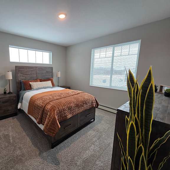 a bedroom with a bed, nightstand, and window.