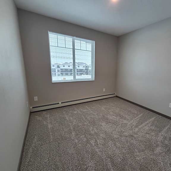 a room with a window and carpeted floor.