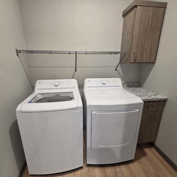 two white front loading washing machines in a laundry room.