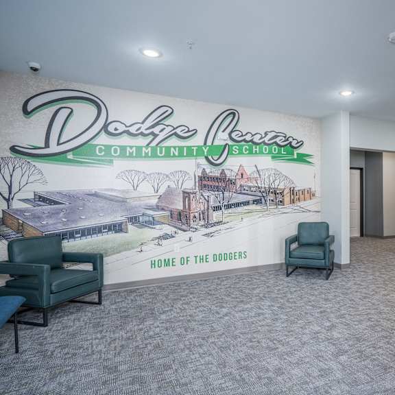 a lobby with chairs and a mural on the wall
