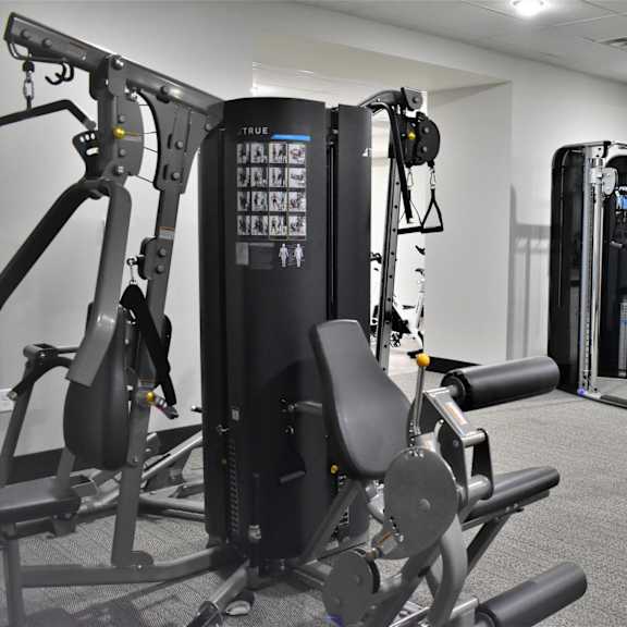 a gym with a variety of equipment including a treadmill, a stationary bike and a rowing machine.