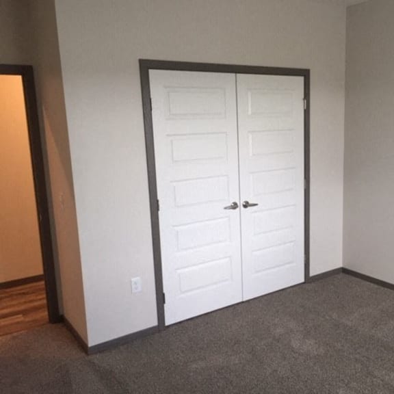 a room with a white door and a carpeted floor