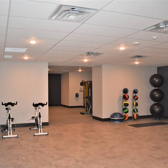 a gym with exercise equipment and a mirror.