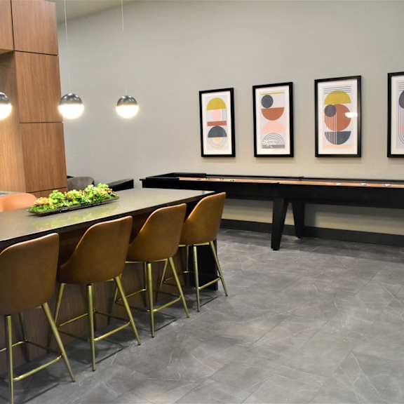 a modern kitchen with a bar area and chairs.