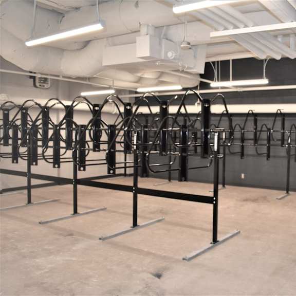 a gym with a row of black weight racks.