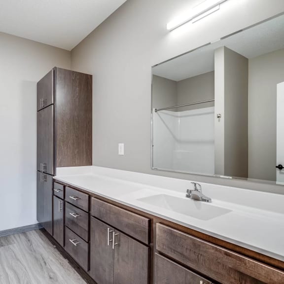 an empty bathroom with a large mirror and a sink