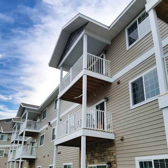 apartment building with balconies and stone accents.