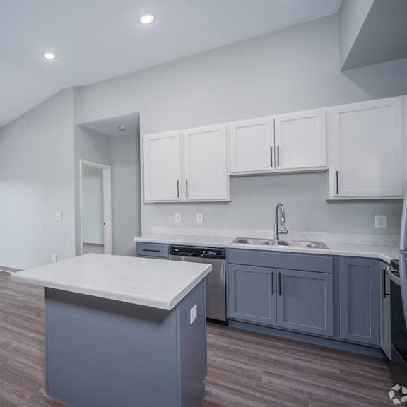 a kitchen with a large island and a door to a balcony