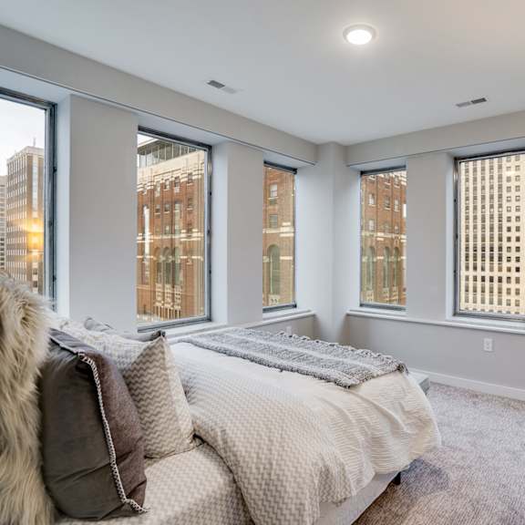 a bedroom with a large bed and a view of the city.