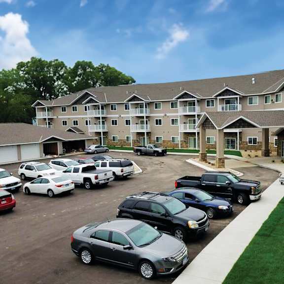 a parking lot with cars and a building in the background.