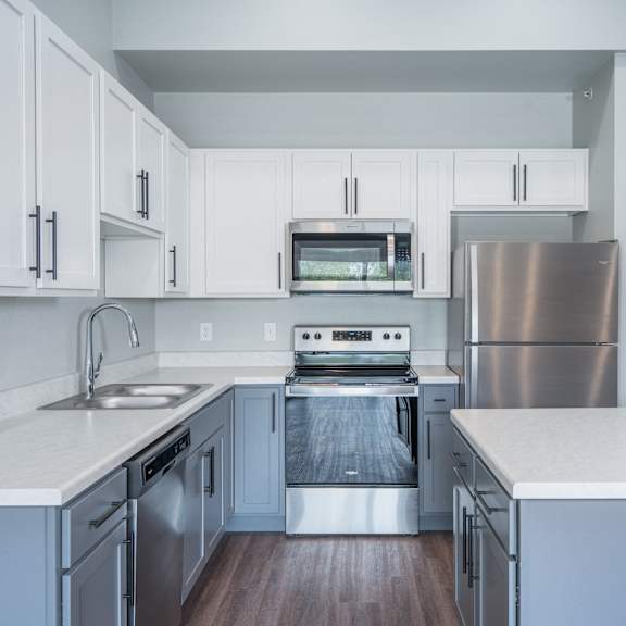 a kitchen with white cabinets and stainless steel appliances