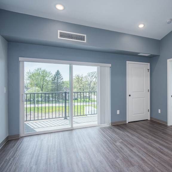 an empty living room with doors and a balcony