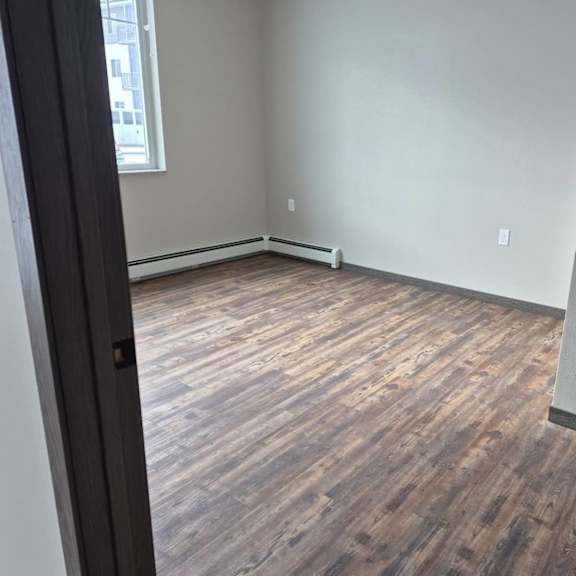 a room with wooden flooring and a window.